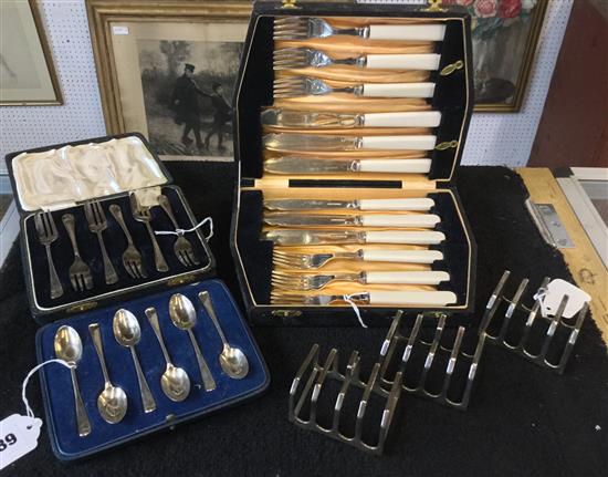 Six silver teaspoons, 6 silver cake forks, 6 pairs of plated fish eaters (all cased) & a set of 4 plated toast racks